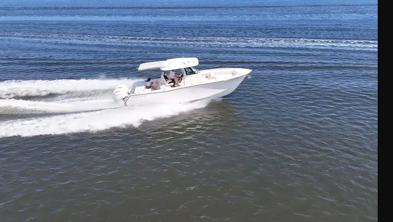Slide: The Image of 2027 Grady-White Canyon 306 speeding across the water with two outboard engines. - 29