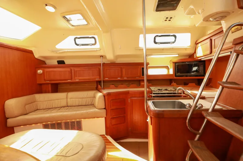 Slide: The Image of 1997 Hunter Passage 42 yacht interior with kitchen, seating, and wooden cabinetry. - 15