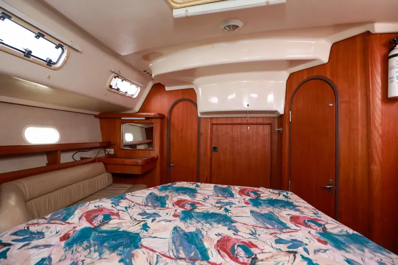 Slide: The Image of Interior cabin of 1997 Hunter Passage 42 sailboat with colorful bedding and wooden accents. - 19