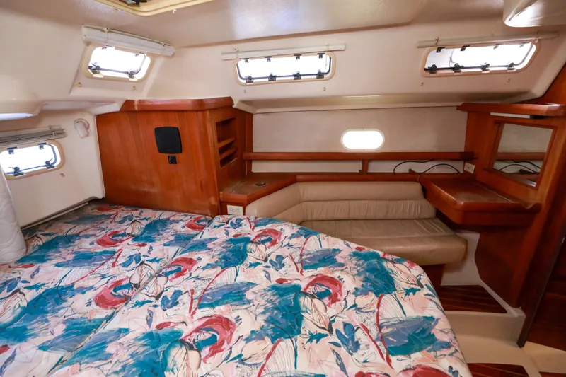 Slide: The Image of 1997 Hunter Passage 42 yacht interior with colorful bedding and wooden cabinetry. - 22