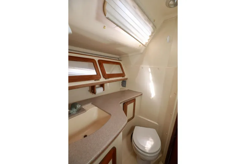 Slide: The Image of 1997 Hunter Passage 42 yacht bathroom with sink, toilet, and wooden accents. - 23