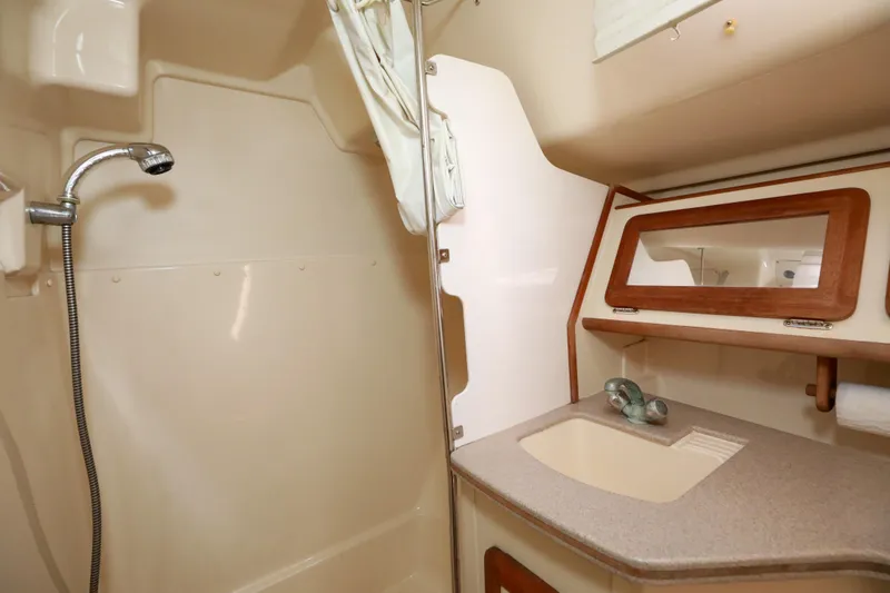 Slide: The Image of 1997 Hunter Passage 42 yacht bathroom with shower, sink, and wooden accents. - 25
