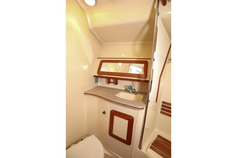 Slide: The Image of 1997 Hunter Passage 42 yacht bathroom with sink, mirror, and wooden accents. - 27
