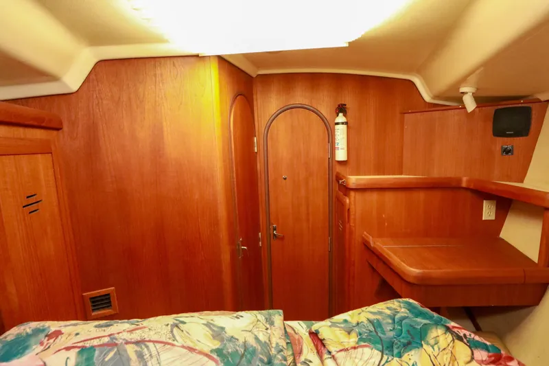 Slide: The Image of Interior of 1997 Hunter Passage 42 sailboat with wooden paneling and colorful bedding. - 30