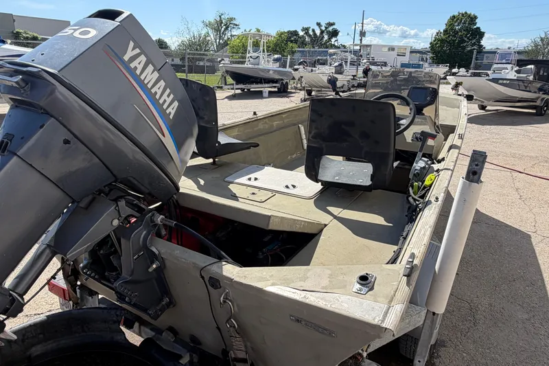 Slide: The Image of 2003 Xpress 1650VJF boat with Yamaha outboard motor, parked outdoors. - 11