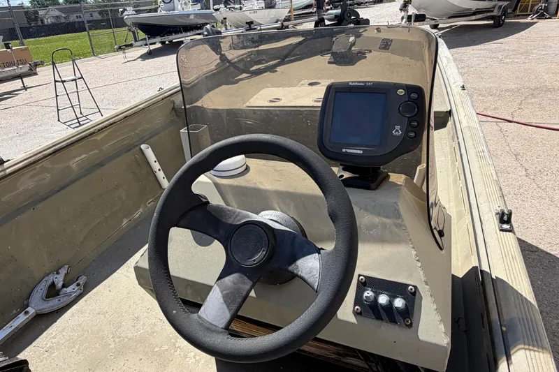 Slide: The Image of 2003 Xpress 1650VJF boat interior with steering wheel and navigation system. - 12