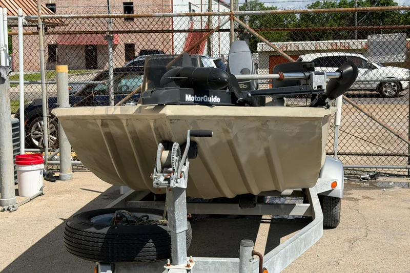 Slide: The Image of 2003 Xpress 1650VJF boat on trailer with MotorGuide motor in a fenced area. - 5