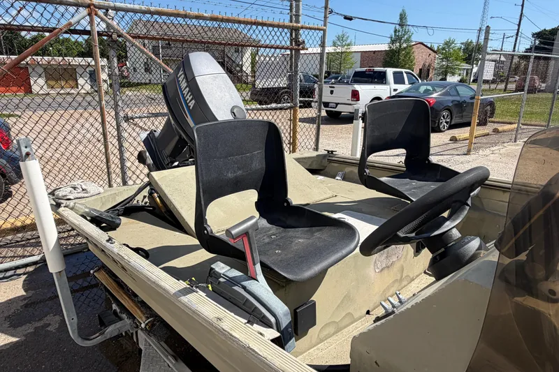 Slide: The Image of 2003 Xpress 1650VJF boat with Yamaha motor, parked near a chain-link fence. - 8