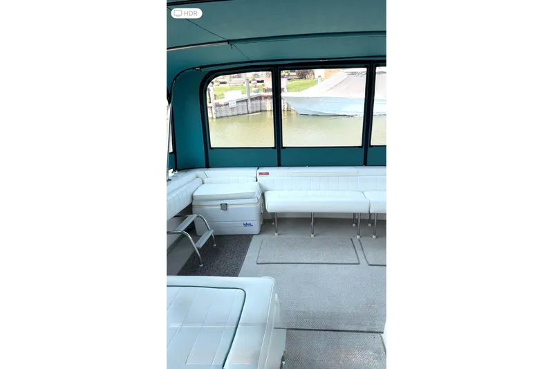 Slide: The Image of Interior of 1994 Sea Ray 310 Amberjack boat with white seating and waterfront view. - 10