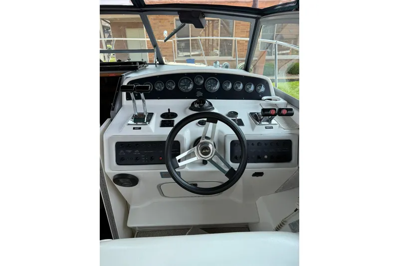 Slide: The Image of Cockpit of 1994 Sea Ray 310 Amberjack boat with steering wheel and control panel. - 11