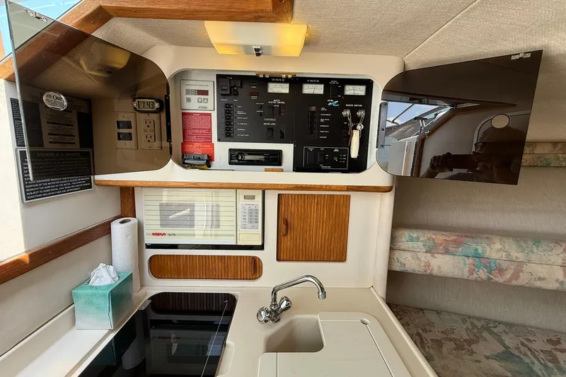 Slide: The Image of Interior of 1994 Sea Ray 310 Amberjack boat with control panel and kitchenette. - 12