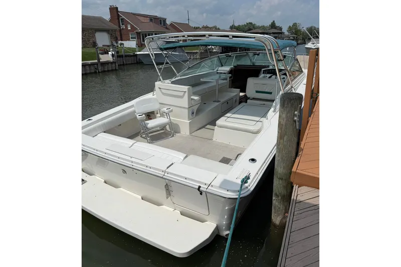 Slide: The Image of 1994 Sea Ray 310 Amberjack docked, featuring spacious seating and open deck layout. - 3