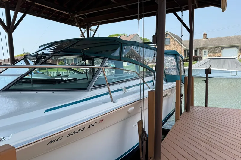 Slide: The Image of 1994 Sea Ray 310 Amberjack docked under a covered marina, showcasing sleek design. - 4