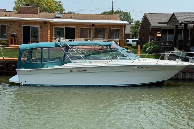 Slide: The Image of 1994 Sea Ray 310 Amberjack boat docked by waterfront homes. - 5
