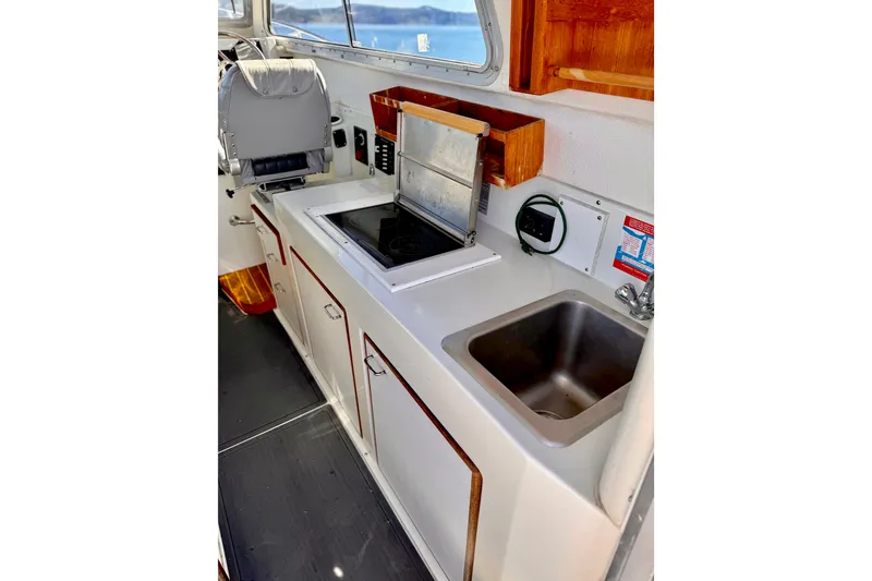 Slide: The Image of 2001 Skagit Orcas 27XLC boat interior with kitchenette, stove, and sink. - 13