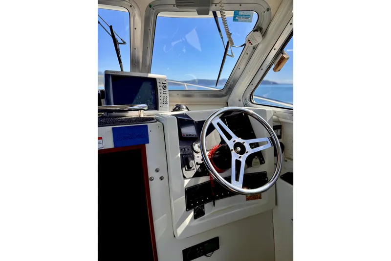 Slide: The Image of Interior view of 2001 Skagit Orcas 27XLC boat cockpit with steering wheel and navigation equipment. - 15