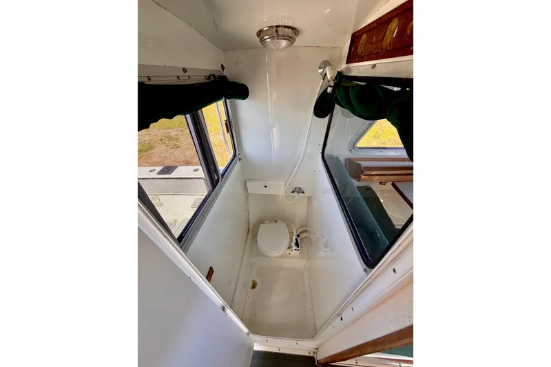 Slide: The Image of Compact bathroom in a 2001 Skagit Orcas 27XLC boat, featuring a toilet and shower. - 18