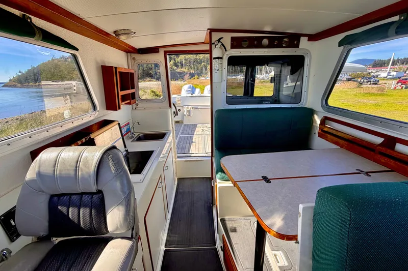 Slide: The Image of Interior of 2001 Skagit Orcas 27XLC boat with seating and kitchenette, near scenic waterfront. - 19