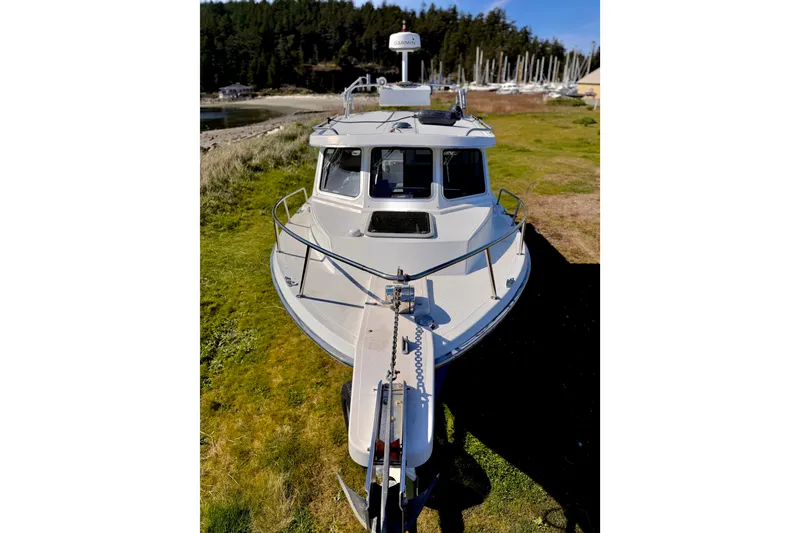 Slide: The Image of 2001 Skagit Orcas 27XLC boat on grassy shore with marina background. - 3