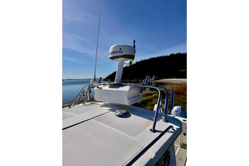 Slide: The Image of 2001 Skagit Orcas 27XLC boat with Garmin radar, docked by scenic shoreline. - 4