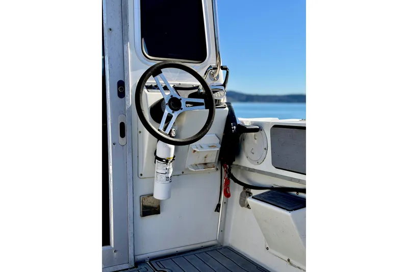 Slide: The Image of Steering wheel of a 2001 Skagit Orcas 27XLC boat with ocean view. - 8
