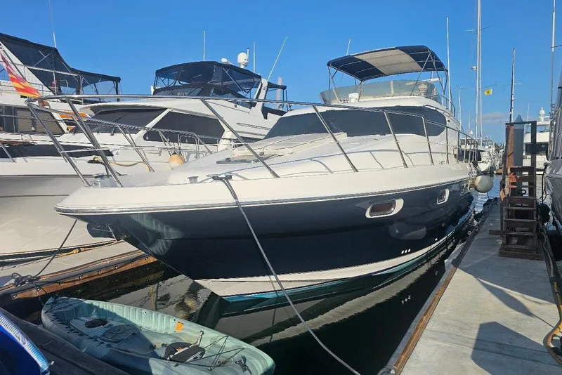 The Image of 2000 Sealine T51 Motor Yacht docked at marina, surrounded by other boats. - 0