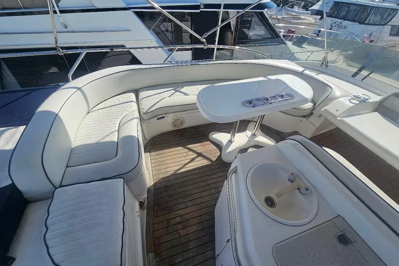 Slide: The Image of Luxurious seating area on a 2000 Sealine T51 Motor Yacht with wooden deck and table. - 10