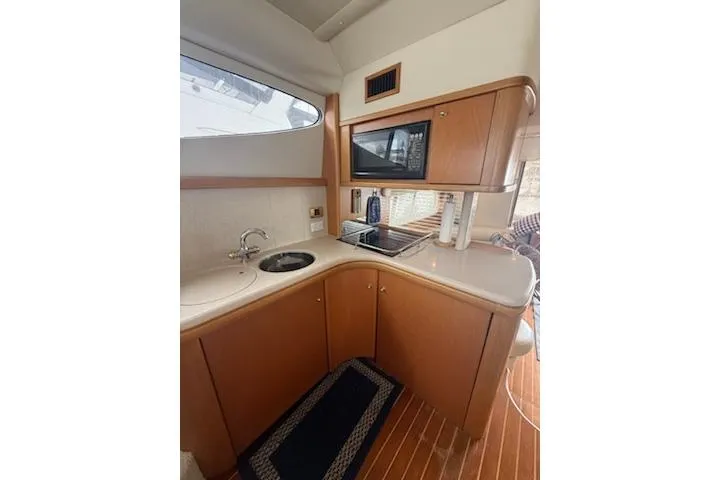 Slide: The Image of Compact kitchen area in a 2000 Sealine T51 yacht with wooden cabinetry and modern appliances. - 14