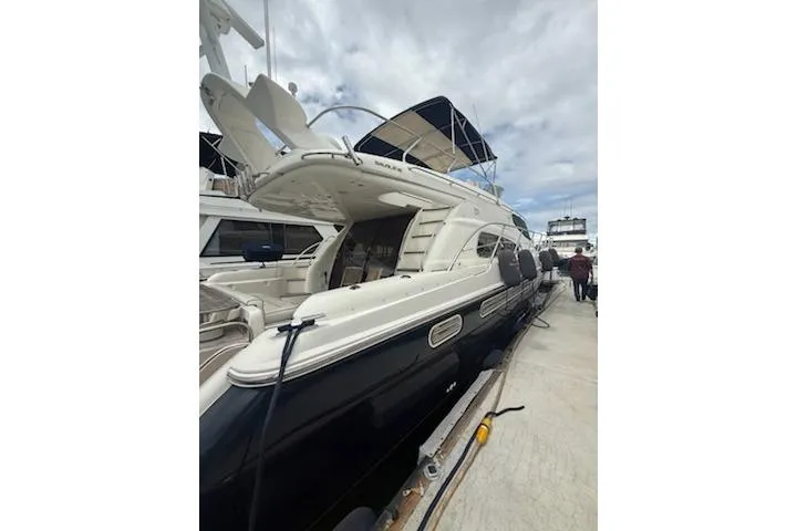 Slide: The Image of 2000 Sealine T51 yacht docked, featuring sleek design and spacious deck. - 2