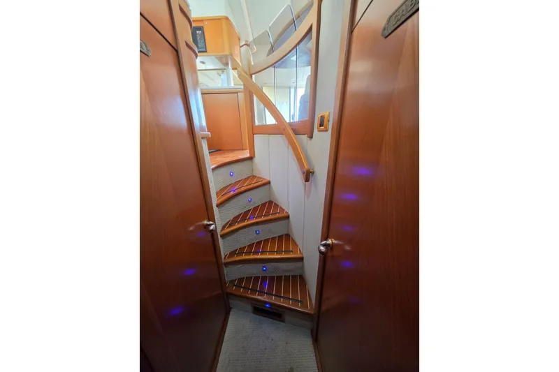 Slide: The Image of Interior staircase of 2000 Sealine T51 MY yacht with wooden steps and ambient lighting. - 23