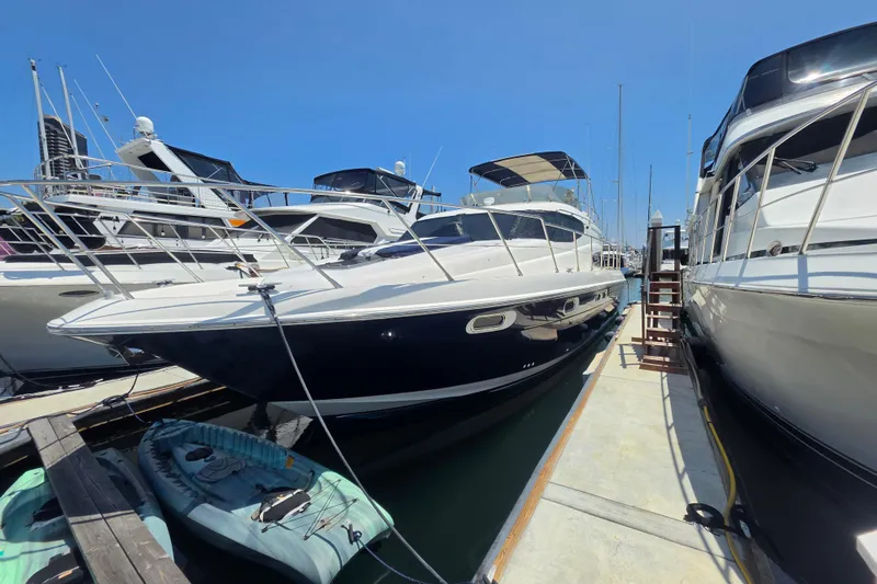 Slide: The Image of 2000 Sealine T51 MY yacht docked at marina, surrounded by other boats under clear blue sky. - 35
