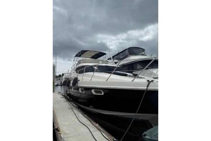 Slide: The Image of 2000 Sealine T51 yacht docked under cloudy skies. - 4