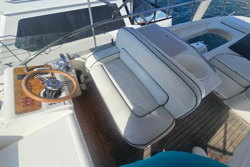 Slide: The Image of Cockpit of 2000 Sealine T51 Motor Yacht with wooden steering wheel and white seating. - 6