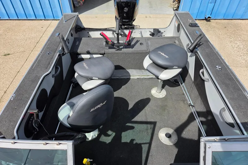 Slide: The Image of 2016 Alumacraft Trophy 175 boat interior with seating and fishing rod holders. - 11