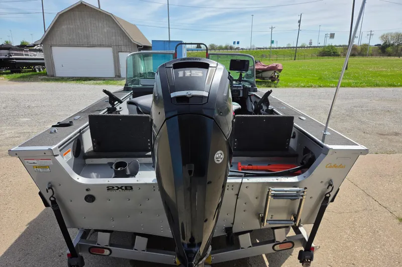 Slide: The Image of 2016 Alumacraft Trophy 175 boat with Mercury outboard motor, parked outdoors. - 3