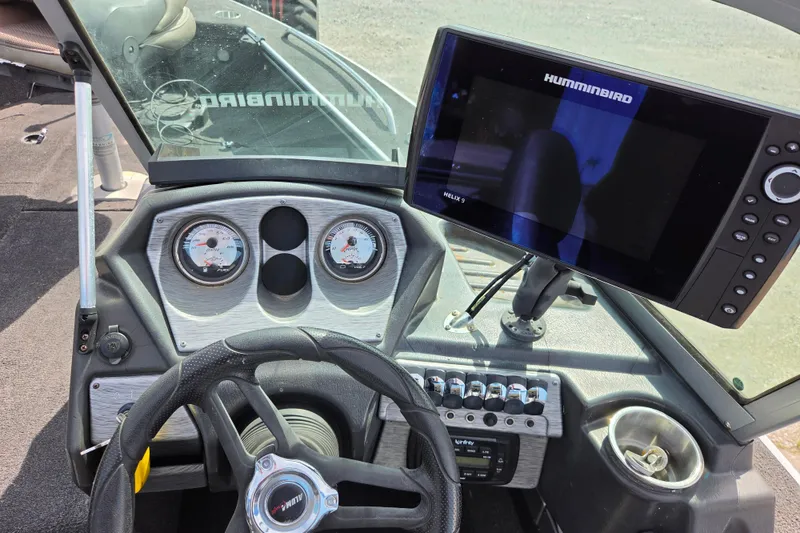 Slide: The Image of 2016 Alumacraft Trophy 175 dashboard with steering wheel and Humminbird Helix 9 fish finder. - 6