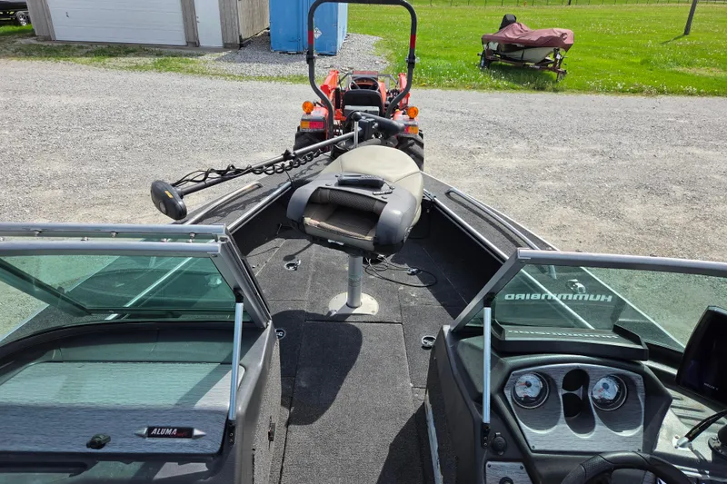 Slide: The Image of 2016 Alumacraft Trophy 175 boat interior with seating and control panel, parked outdoors. - 7