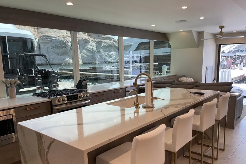Slide: The Image of Modern kitchen with island seating, large windows, and scenic waterfront view. - 11