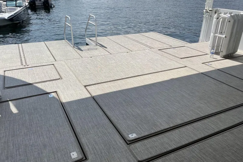 Slide: The Image of Floating dock with textured surface, ladder, and boat access on calm water. - 16