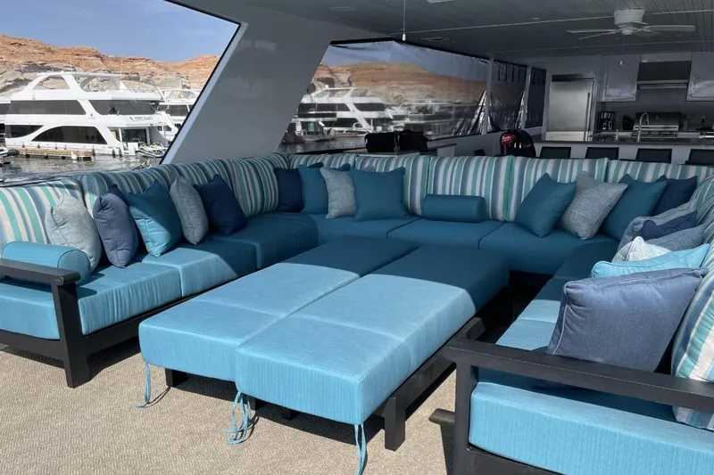 Slide: The Image of Luxurious yacht interior with blue cushioned seating, striped pillows, and marina view. - 18