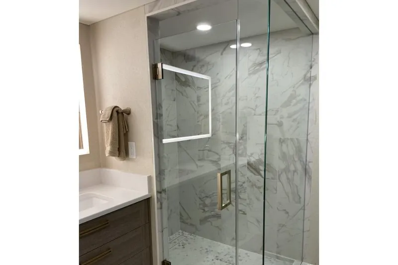 Slide: The Image of Modern bathroom with glass shower, marble tiles, and sleek fixtures in Adonia Max'd Out Trip model. - 2