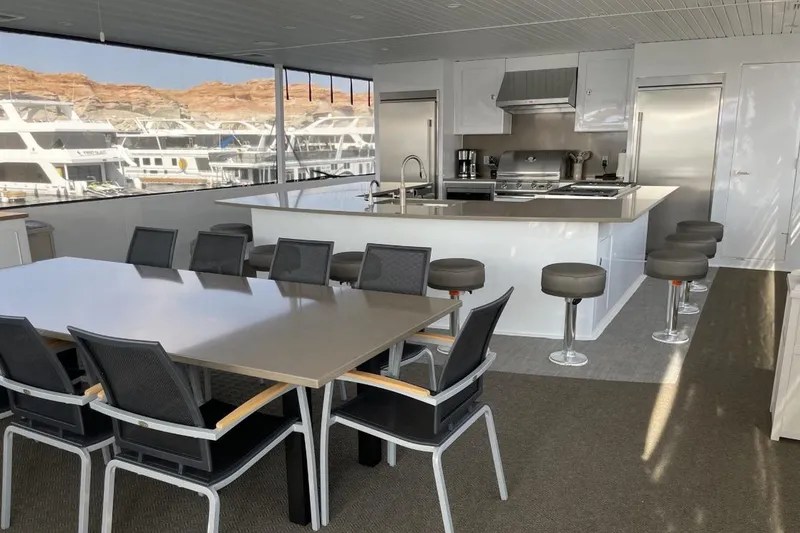 Slide: The Image of Luxurious yacht interior with modern kitchen and dining area, featuring sleek design and ample seating. - 20