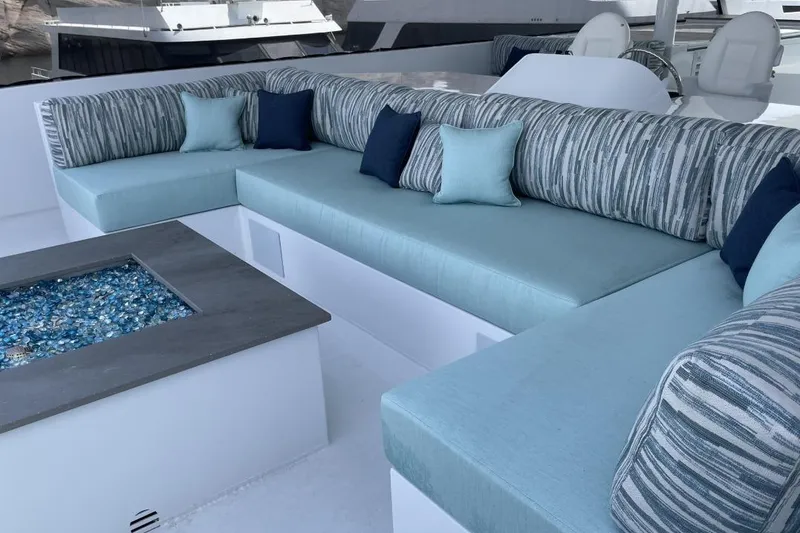 Slide: The Image of Luxurious yacht seating area with blue cushions and decorative pillows, featuring a glass-topped table. - 21