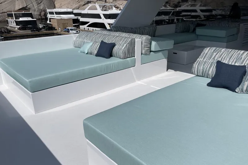 Slide: The Image of Luxurious yacht deck with cushioned seating, featuring elegant blue and striped pillows. - 22
