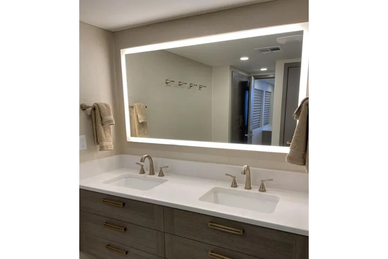 Slide: The Image of Modern bathroom with dual sinks, illuminated mirror, and beige towels. - 6