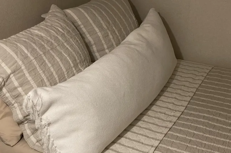 Slide: The Image of Cozy bed with striped pillows and a textured white bolster, Adonia Max'd Out Trip 2021. - 7