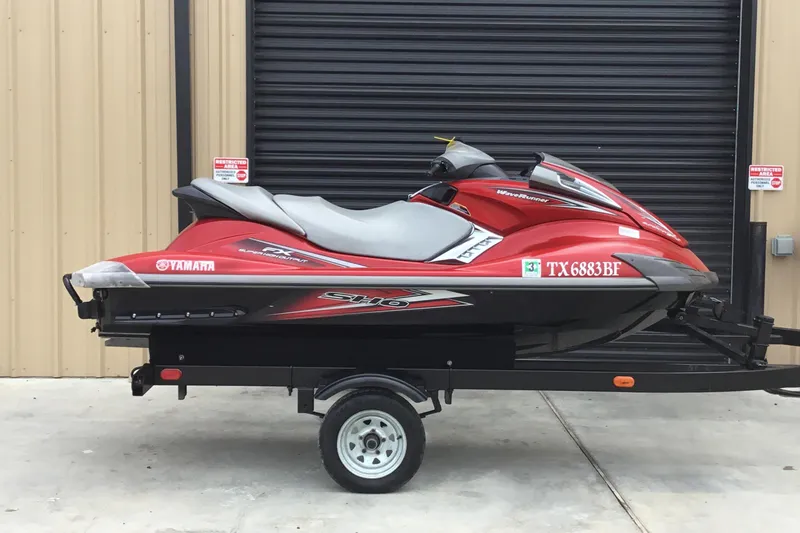 The Image of 2010 Yamaha FX SHO jet ski on trailer, red and gray, parked outside. - 1