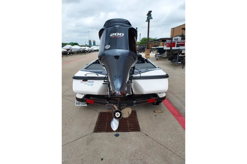 Slide: The Image of 2021 Skeeter ZX200 boat with powerful outboard motor, parked on concrete surface. - 10