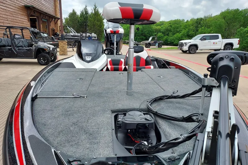 Slide: The Image of 2021 Skeeter ZX200 bass boat with red and black seating, parked outdoors. - 4