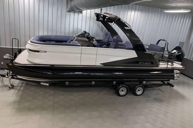 The Image of 2025 Sylvan M3 DLZ DH Tritoon boat in showroom, featuring sleek design and modern amenities. - 0